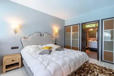 a bedroom with a large white bed in a room at Villa Emilia, vue mer, Super-Cannes in Vallauris