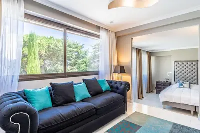 a living room with a couch and a large window at Villa Emilia, vue mer, Super-Cannes in Vallauris