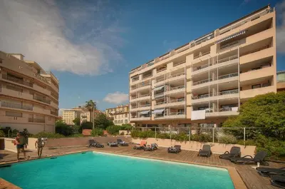 a swimming pool in front of a building at Fil - Piscine - 2 min Mer - VCA in Cannes