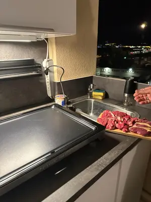 a kitchen counter with a sink and meat on a cutting board at Azuria in Cannes
