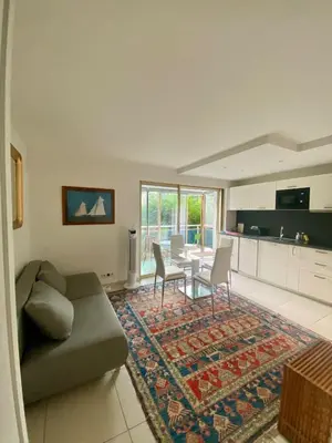 a living room with a couch and a table at Lovely Flat with Covered Balcony in Cannes in Cannes