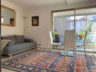 a living room with a couch and a rug at Lovely Flat with Covered Balcony in Cannes in Cannes