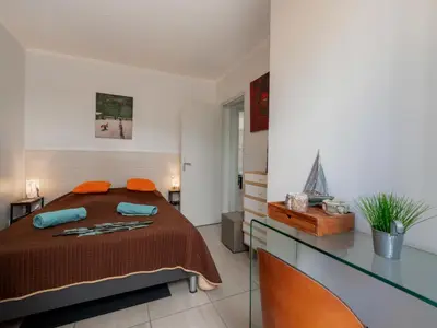 a bedroom with a large bed with orange pillows at Apartment Les Girelles by Interhome in Cannes