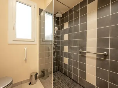 a bathroom with a shower with a toilet and a window at Apartment Les Girelles by Interhome in Cannes