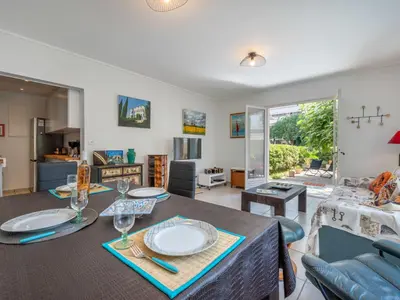 a dining room and living room with a table and chairs at Apartment Les Girelles by Interhome in Cannes