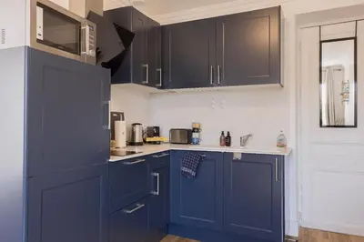 a kitchen with blue cabinets and a counter top at Studio Jasmin - calme charmant clim Palais & plage in Cannes