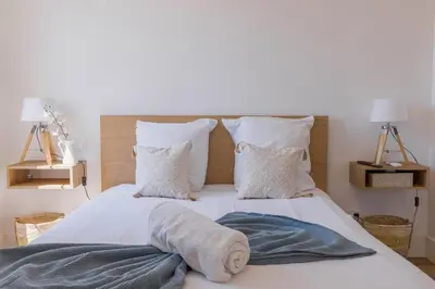 a bedroom with a large bed with white sheets and pillows at Studio Jasmin - calme charmant clim Palais & plage in Cannes