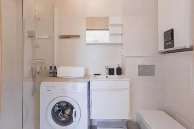 a bathroom with a washing machine and a washer at Studio Jasmin - calme charmant clim Palais & plage in Cannes