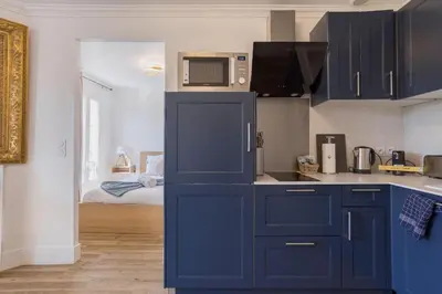 a kitchen with blue cabinets and a microwave at Studio Jasmin - calme charmant clim Palais & plage in Cannes