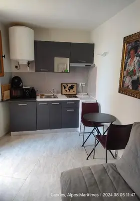 a kitchen with a sink and a table with chairs at Chante Brise Studio in Cannes
