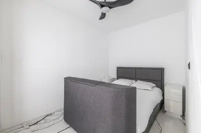 a white bedroom with a bed and a television at LB Vacation Rentals I A Quiet Place with Terrace in the Heart of Cannes in Cannes