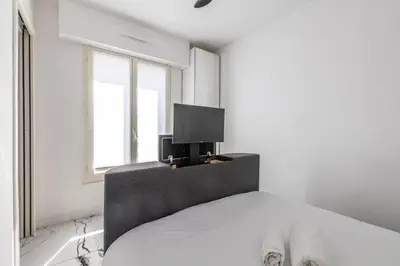 a bedroom with a bed with a tv on it at LB Vacation Rentals I A Quiet Place with Terrace in the Heart of Cannes in Cannes