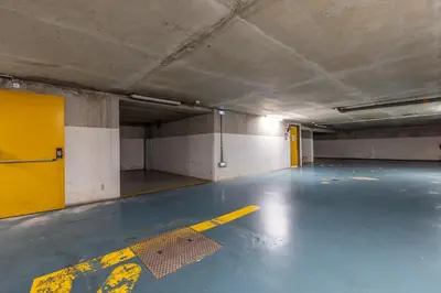 an empty parking garage with a yellow door at LB Vacation Rentals I A Quiet Place with Terrace in the Heart of Cannes in Cannes