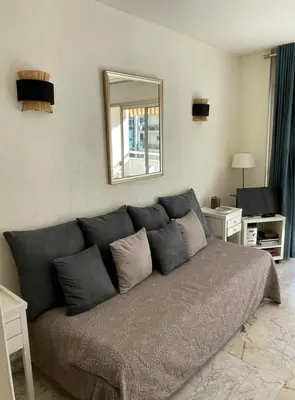 a large gray couch in a living room with a mirror at studio standing cannes croisette in Cannes