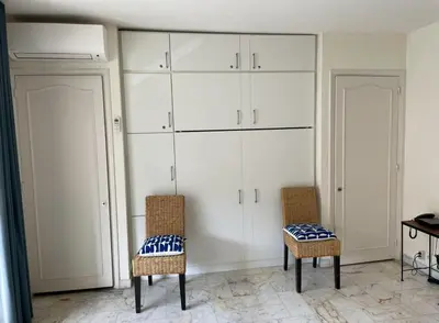 a room with two chairs and white cabinets at studio standing cannes croisette in Cannes
