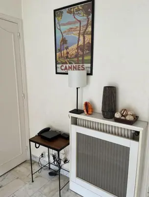 a living room with a fireplace and a picture on the wall at studio standing cannes croisette in Cannes