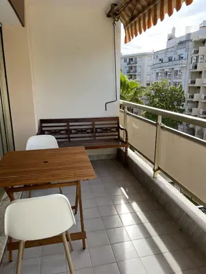 a balcony with a wooden table and two chairs at studio standing cannes croisette in Cannes