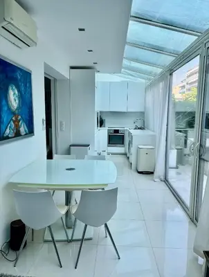 a white kitchen with a white table and chairs at Jardin sur la Pointe Croisette Luxe en Bord de Mer in Cannes