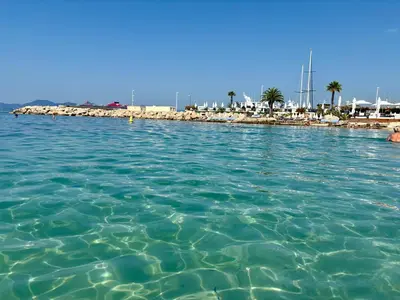 a large body of water with a pier in the background at Jardin sur la Pointe Croisette Luxe en Bord de Mer in Cannes