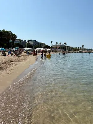 a beach with a group of people in the water at Jardin sur la Pointe Croisette Luxe en Bord de Mer in Cannes