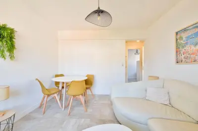 a living room with a couch and a table at Cosy 1 BR Flat with balcony near La Croisette in Cannes