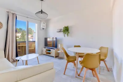 a living room with a table and a couch at Cosy 1 BR Flat with balcony near La Croisette in Cannes