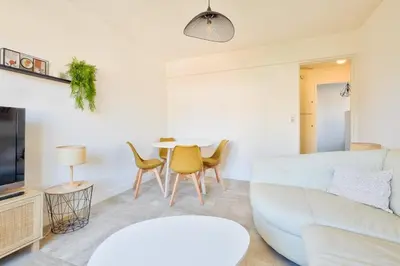 a living room with a white couch and a table at Cosy 1 BR Flat with balcony near La Croisette in Cannes