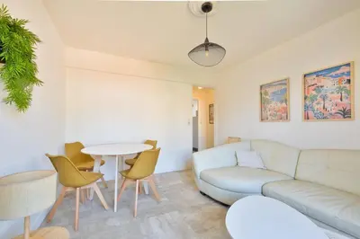 a living room with a couch and a table and chairs at Cosy 1 BR Flat with balcony near La Croisette in Cannes
