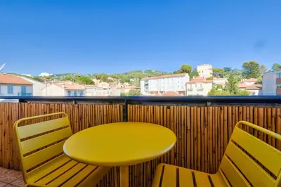 a yellow table and two chairs on a balcony at Cosy 1 BR Flat with balcony near La Croisette in Cannes