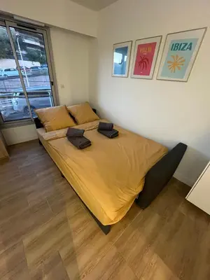 a bedroom with a large bed with yellow sheets at Studio cosy au cœur de Cannes in Cannes