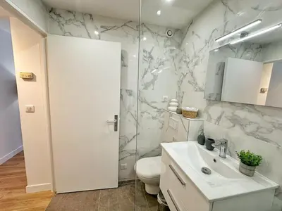 a white bathroom with a toilet and a sink at Studio cosy au cœur de Cannes in Cannes