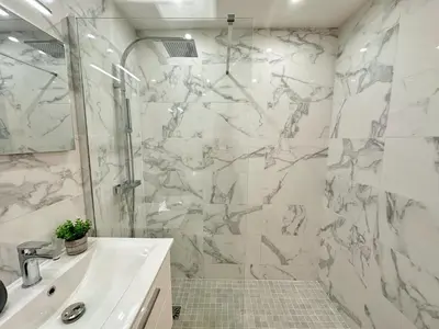 a white bathroom with a shower and a sink at Studio cosy au cœur de Cannes in Cannes