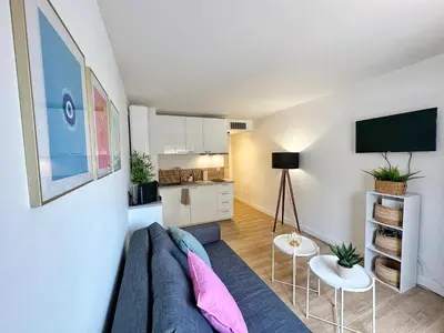 a living room with a couch and a tv at Studio cosy au cœur de Cannes in Cannes