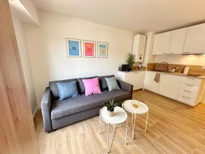 a living room with a couch and two tables at Studio cosy au cœur de Cannes in Cannes