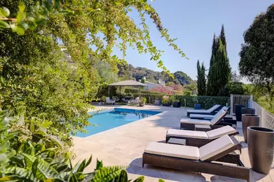a swimming pool with lounge chairs next to a swimming pool at La Villa Julia Two in Vallauris