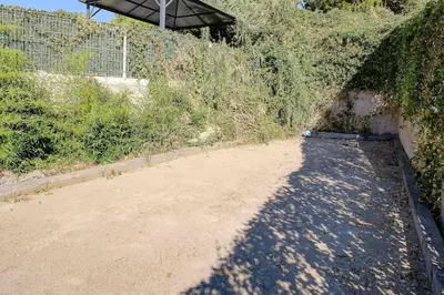 a dirt road next to a fence with a shadow at La Villa Julia Two in Vallauris