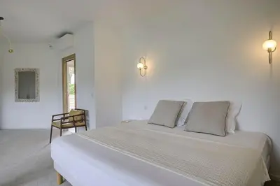 a white bedroom with a large bed with two pillows at La Villa Julia Two in Vallauris
