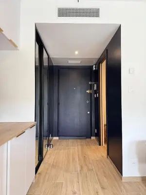 a hallway with a black door and wooden floors at Studio Riviera, Centre-ville Cannes, Terrasse, Clim in Cannes