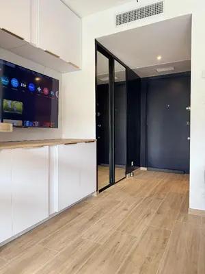 a living room with white cabinets and a hardwood floor at Studio Riviera, Centre-ville Cannes, Terrasse, Clim in Cannes