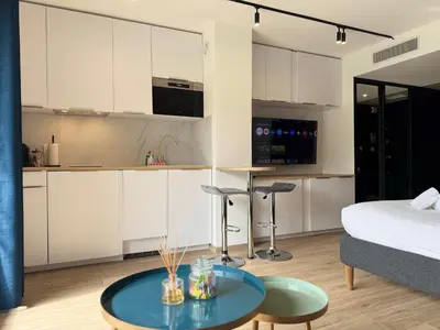 a kitchen and living room with a bed and a table at Studio Riviera, Centre-ville Cannes, Terrasse, Clim in Cannes