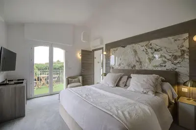 a bedroom with a large bed and a television at Villa Julia First in Vallauris