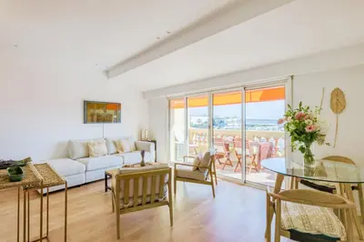 a living room with a white couch and a table at LE VOILIER avec terrasse panoramique vue mer et port, proche du Palais, Croisette et plages in Cannes