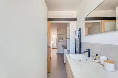 a bathroom with two sinks and a hallway at LE VOILIER avec terrasse panoramique vue mer et port, proche du Palais, Croisette et plages in Cannes