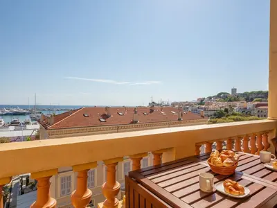 a balcony with a table with food on it at LE VOILIER avec terrasse panoramique vue mer et port, proche du Palais, Croisette et plages in Cannes