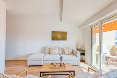 a living room with a white couch and a table at LE VOILIER avec terrasse panoramique vue mer et port, proche du Palais, Croisette et plages in Cannes