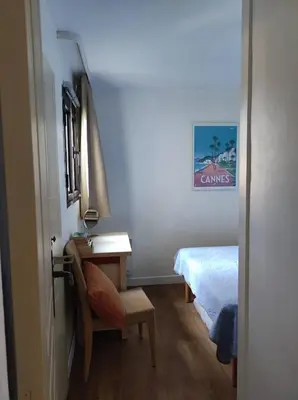 a bedroom with a bed and a desk and a bed at Cannes Villa Francia appartement climatisé vue mer in Cannes