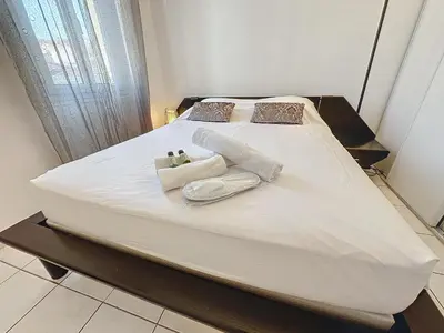 a large white bed with towels and pillows on it at Central 1 bedroom Riouffe 206 2 mins from Palais in Cannes