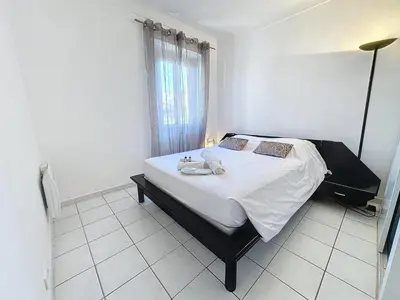 a bedroom with a bed with white sheets and a window at Central 1 bedroom Riouffe 206 2 mins from Palais in Cannes