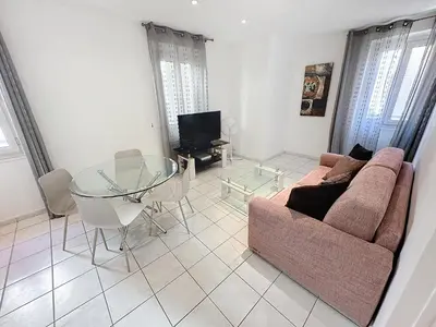 a living room with a couch and a glass table at Central 1 bedroom Riouffe 206 2 mins from Palais in Cannes