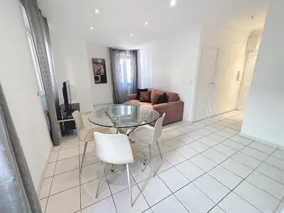 a living room with a glass table and chairs at Central 1 bedroom Riouffe 206 2 mins from Palais in Cannes
